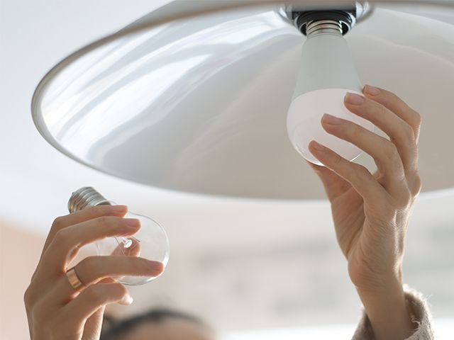 Person changing light bulb
