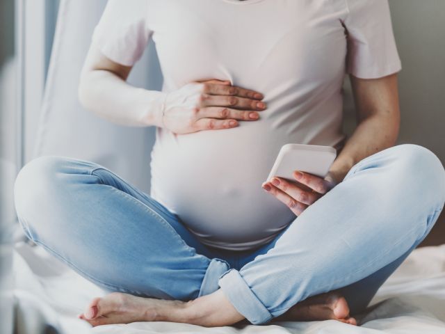 Pregnant person using cellphone